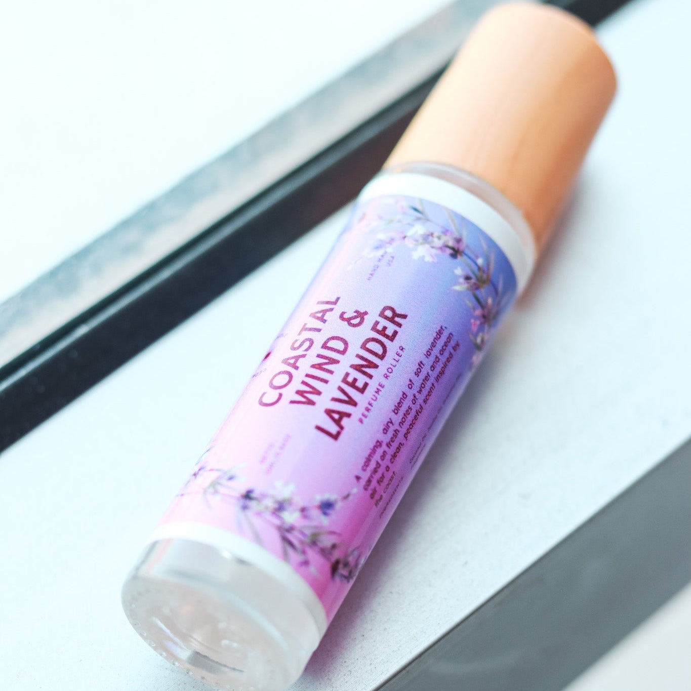 Coastal Wind & Lavender perfume oil on a reflective surface