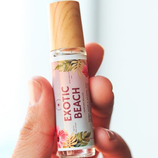 Hand holding a small bottle labeled 'Exotic Beach' against a light background