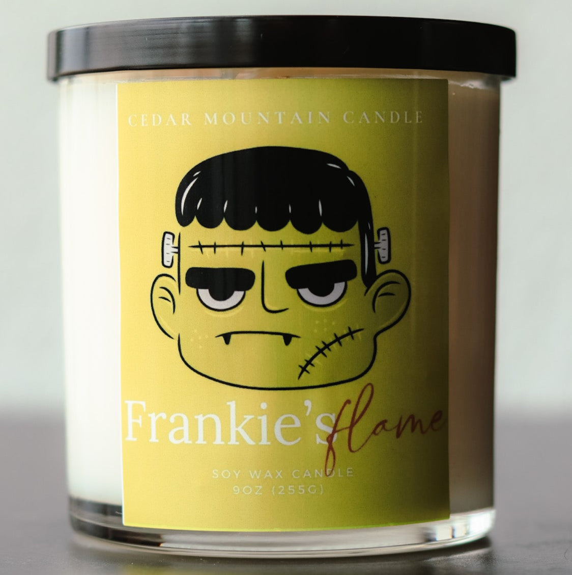 Frankie's Flame Halloween Soy Candle with black lid in 9 oz whiskey glass jar