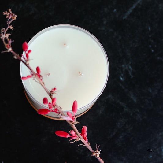 Cedar Mountain Candle 3-wick soy wax candle in glass jar with bamboo lid, topped with red flower sprig.