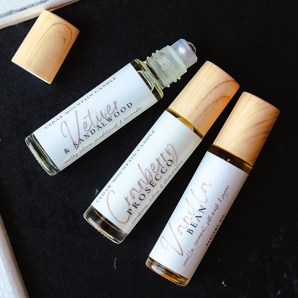 Cedar Mountain Candle roll-on perfume oils in glass bottles with bamboo lids. Scents: Vetiver & Sandalwood, Cranberry Prosecco, Vanilla Bean.
