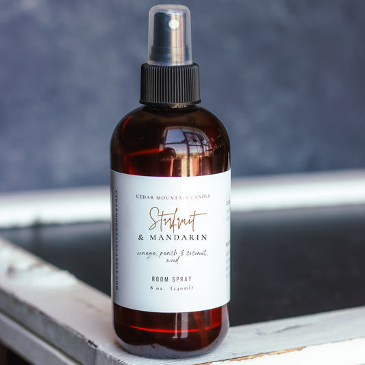 Cedar Mountain Candle Starfruit & Mandarin 8 oz room spray in amber glass bottle with black spray top. Scent notes include orange, peach, and coconut.