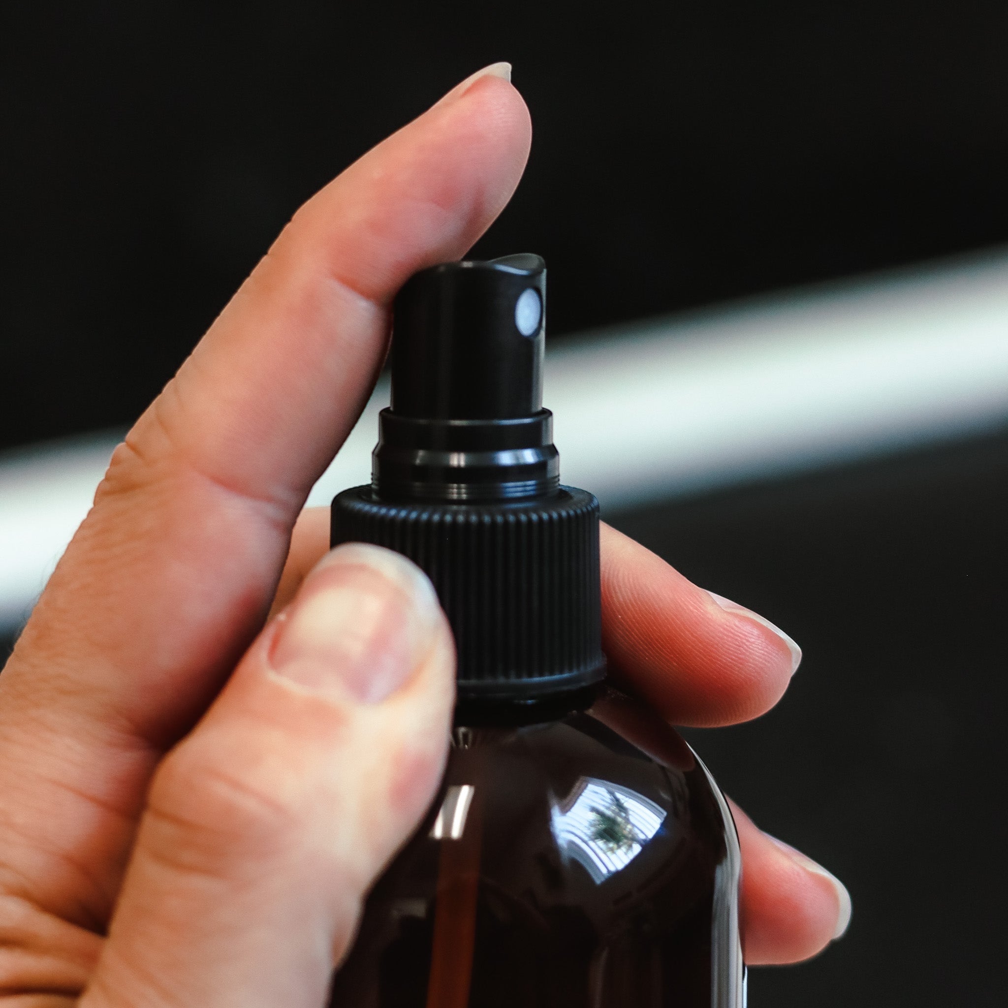 Cedar Mountain Candle 8 oz Starfruit & Mandarin room spray bottle being held and sprayed.