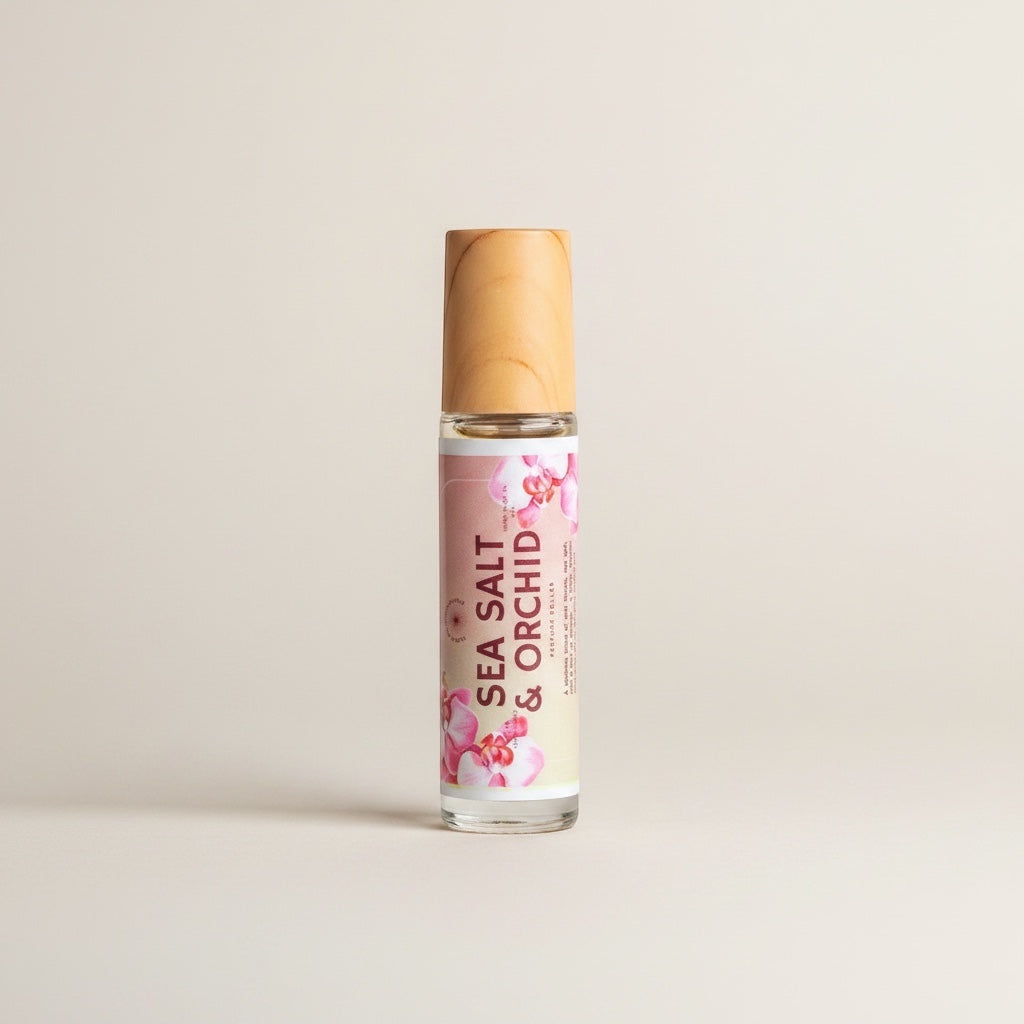 Cedar Mountain Candle Sea Salt & Orchid roll-on perfume oil in a 10ml glass bottle with a bamboo lid, featuring floral orchid accents.