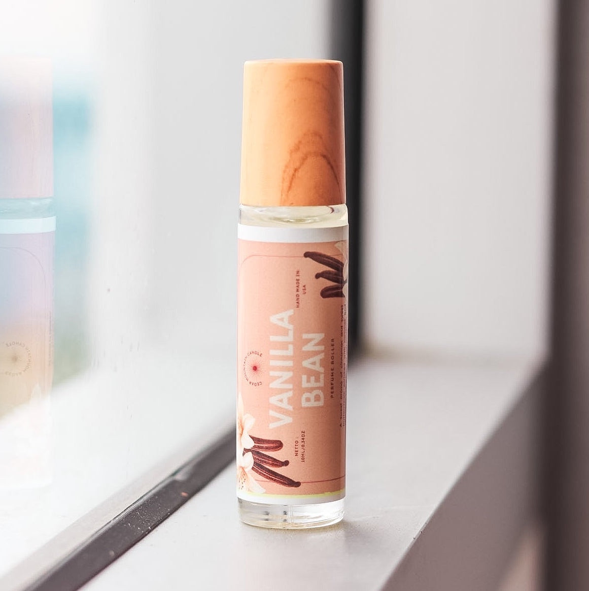 Cedar Mountain Candle Vanilla Bean roll-on perfume oil in a 10ml glass bottle with a bamboo lid. Notes of vanilla, caramel, musk, and sugar.